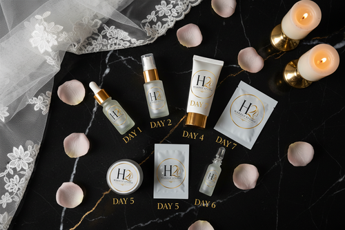 H2 Makeup Studio 7-day bridal skincare box contents flat lay with all 7 products on black marble