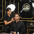 H2 Makeup Studio artist applying natural groom makeup on Indian groom
