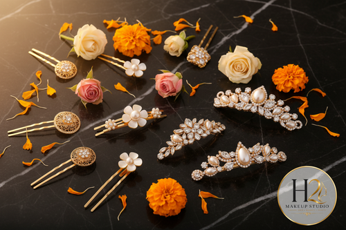 H2 Makeup Studio bridal hair accessories flat lay on black marble with marigold petals